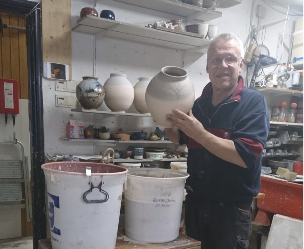 Frans van den Brink met keramiek in zijn pottenbakkerij