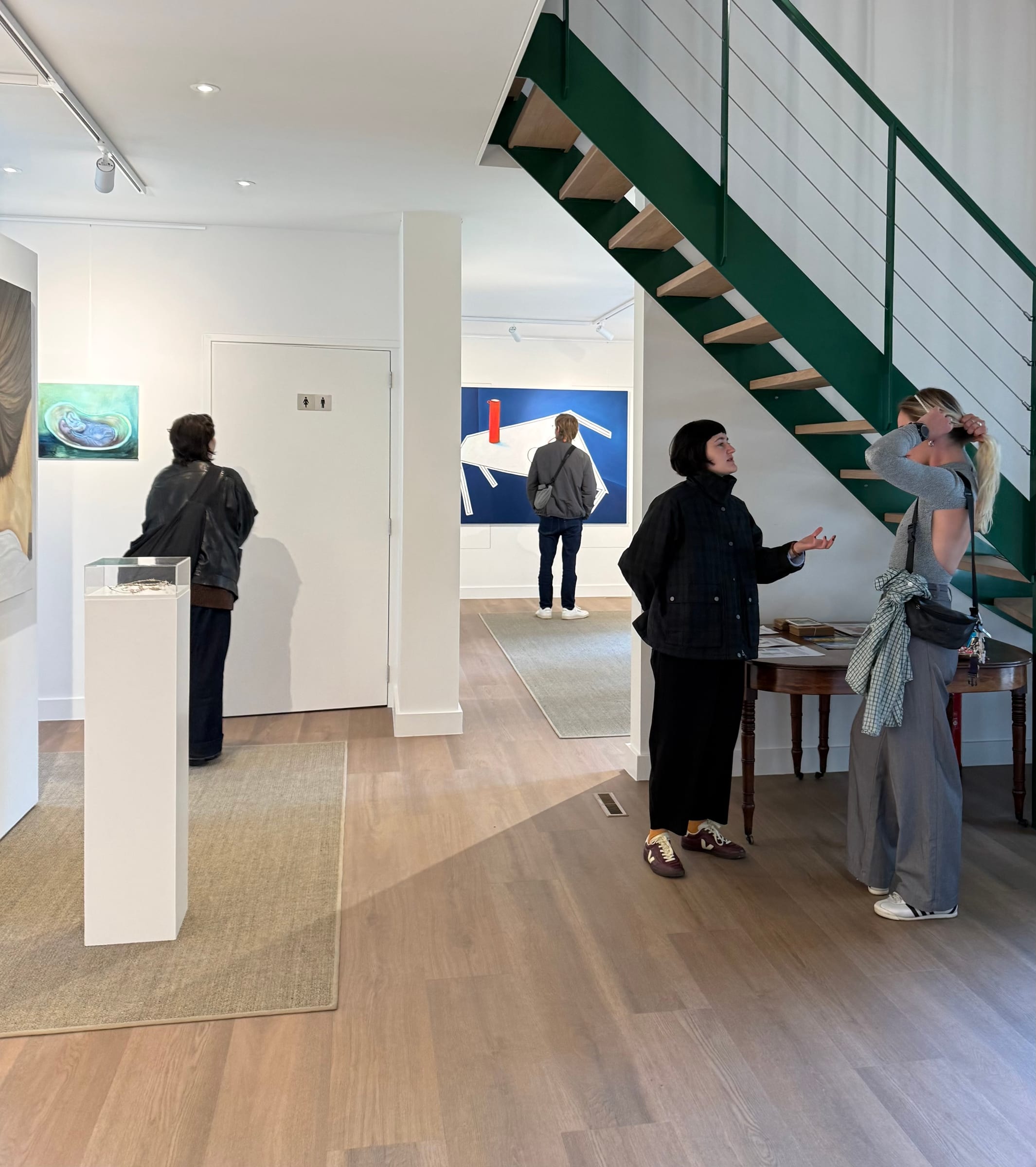 Bezoekers bekijken en bespreken kunstwerken tijdens FRIS! in Galerie Dwingeloo