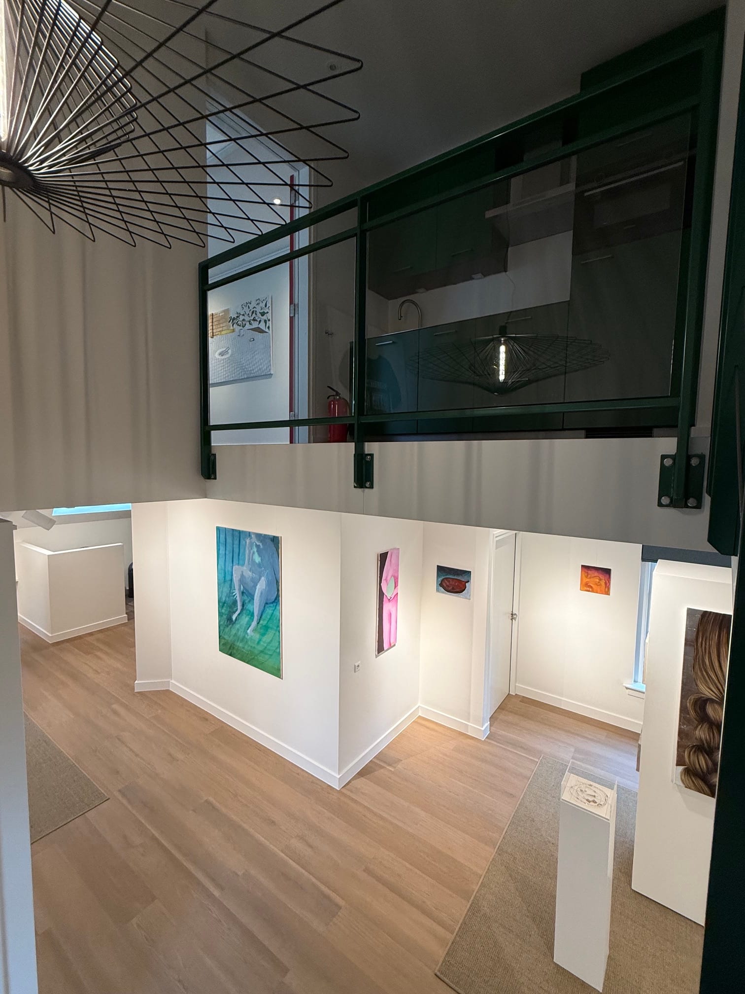 Uitzicht vanaf de verdieping op kunstwerken en de galerieruimte tijdens FRIS!