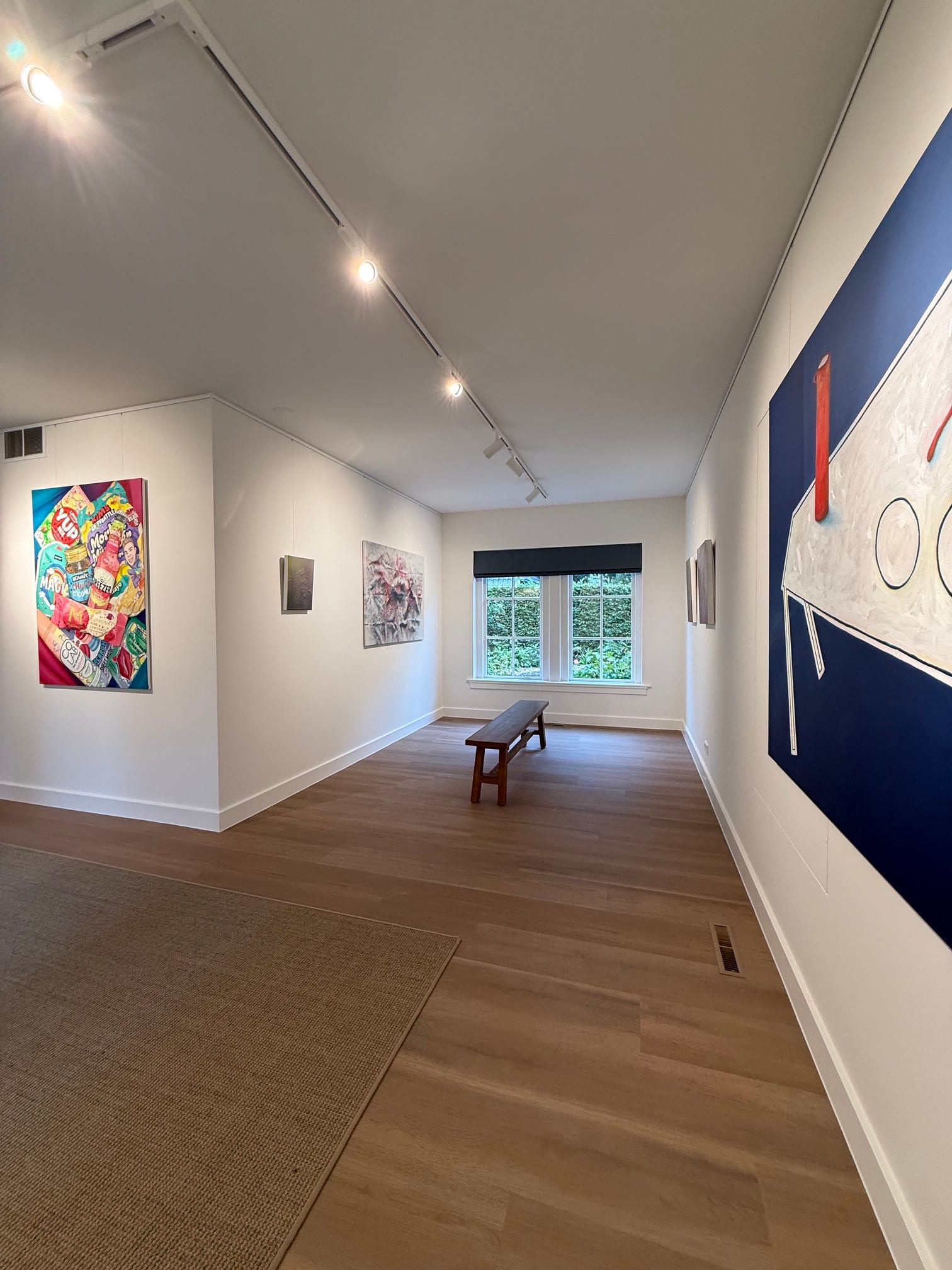 Galerieruimte met kleurrijke schilderijen en een bank tijdens FRIS!