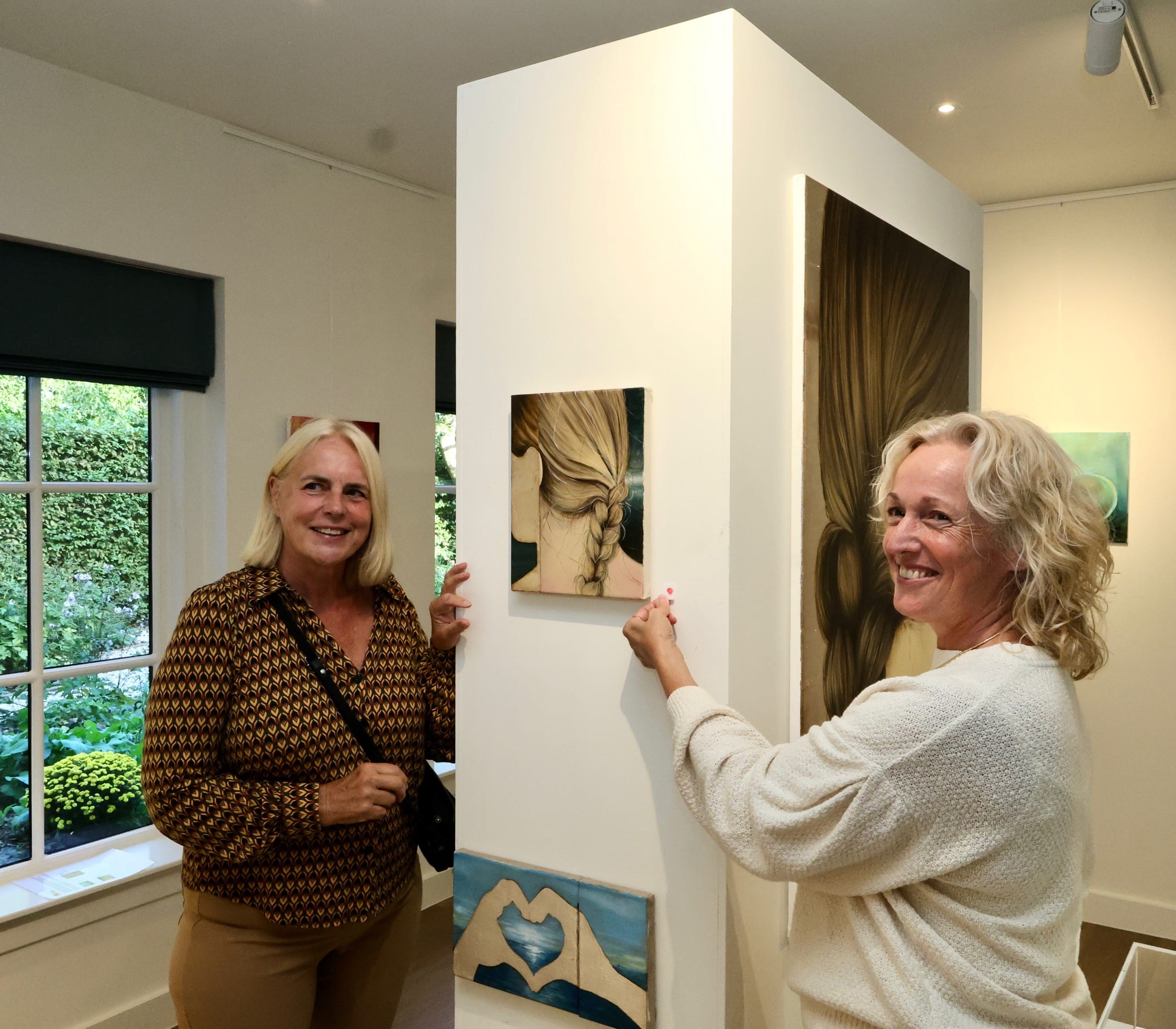 Twee bezoekers bij schilderijen tijdens de opening van FRIS!